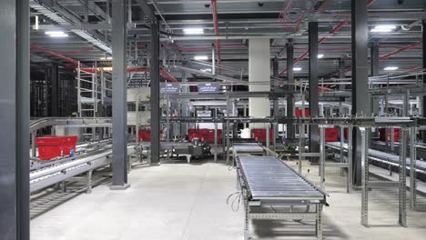 Automated-packaging-line-in-ecommerce-warehouse,-baskets-move-on-conveyor-belt-to-complete-online-order