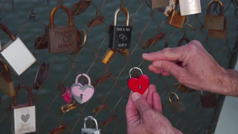 Locking-red-heart-padlock-on-fence-of-love-lock-bridge-in-Rotterdam