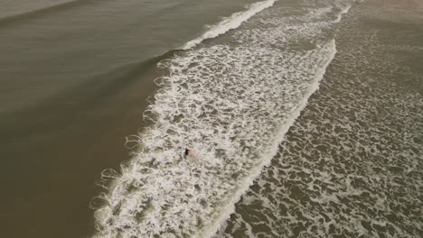 Isolated-surfer-enters-Atlantic-Ocean-water-of-La-Pedrera-Beach,-Uruguay