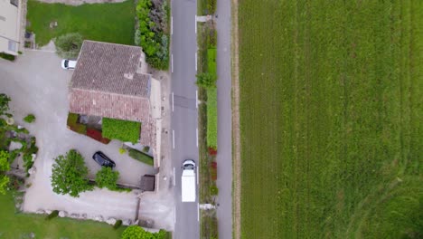 Birds-eye-view-tracking-shot-of-a-white-good-van-traveling-through-the-countryside