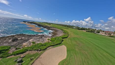 Fpv-flight-over-Beautiful-green-golf-court-and-rocky-coastline-with-blue-Caribbean-seascape-in-summer