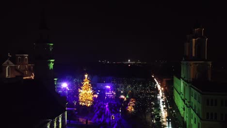 Glowing-Kaunas-Christmas-tree,-aerial-view-from-corner-of-square
