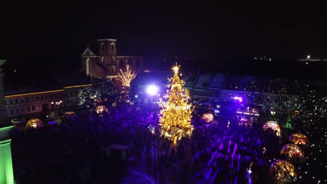 Town-Hall-Square-with-glowing-Christmas-tree-of-Kaunas,-aerial-orbit-view