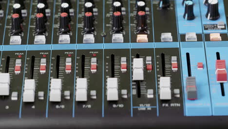 Closeup-of-a-finger-pushing-a-button-on-an-audio-mixer