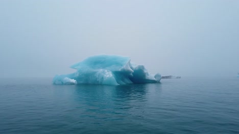 Pasando-Un-Iceberg-Azul-Brillante-En-La-Laguna-Del-Glaciar-Jokusarlon-En-El-Sur-De-Islandia