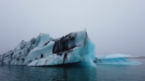 Acercándose-A-Un-Gran-Iceberg-Negro-Y-Azul-En-La-Laguna-Del-Glaciar-Jokusarlon-En-La-Costa-Sur-De-Islandia