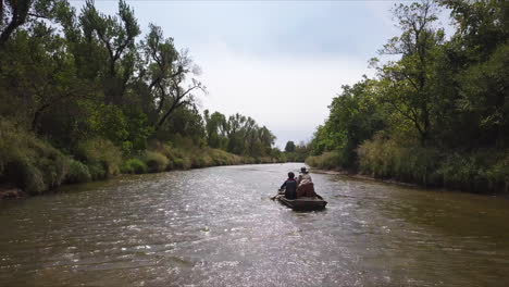 slow-tracking-shot-of-a-family-paddling-upstream-in-a-kayak,-in-Georgia