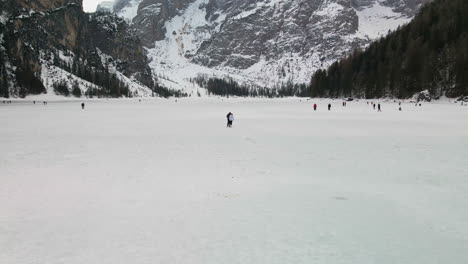 Turistas-Caminando-Sobre-El-Lago-Congelado-Braies-Durante-El-Invierno-En-Trentino,-Italia