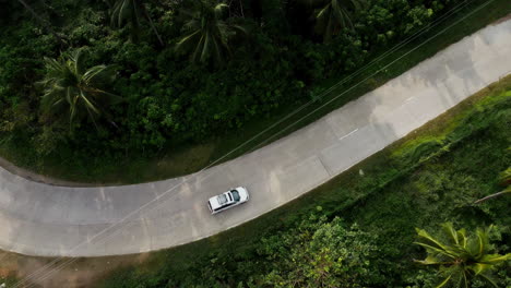 Drone-shot-of-a-car-traveling-a-curve-road