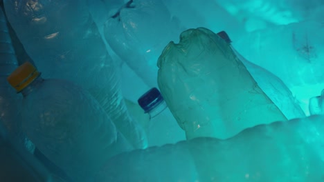 Detailaufnahme-Von-Leeren-Wasserflaschen,-Die-Mit-Blauem-Und-Grünem-Licht-Beleuchtet-Werden-Und-Die-Farbe-ändern