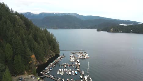 Extraordinary-reveal-Shot-of-a-Motorboats-,-Yachts-and-Sailboats-mooring-at-deep-cove-marina-on-the-Indian-Arm-in-Deep-Cove-North-Vancouver