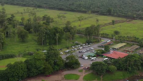 Rural-community-near-Tarcoles-river-with-boats-in-San-Jose,-Costa-Rica-with-vehicle-transportation,-Aerial-pan-right-shot
