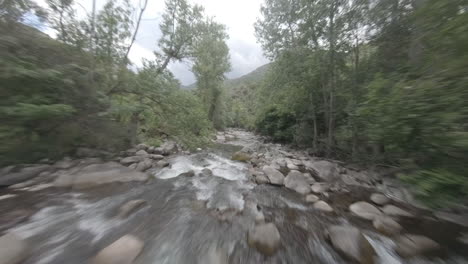 FPV-drone-flies-along-river-stream-close-to-water-current-in-Esterri-D'aneu