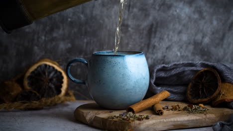 Pouring-Tea-in-blue-vintage-cup-on-moody-background