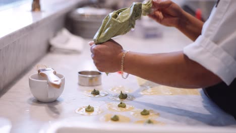 Female-chef-piping-tortellini-handmade-in-kitchen,-slow-motion