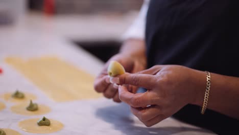 Female-chef-folding-tortellini-in-slow-motion,-tight