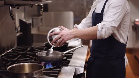 Chef-pouring-meat-into-pan-and-stirring,-medium