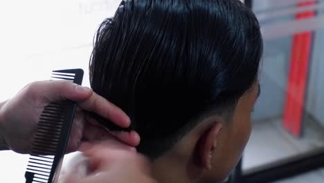 A-hairdresser-makes-a-mens-haircut-in-a-barbershop