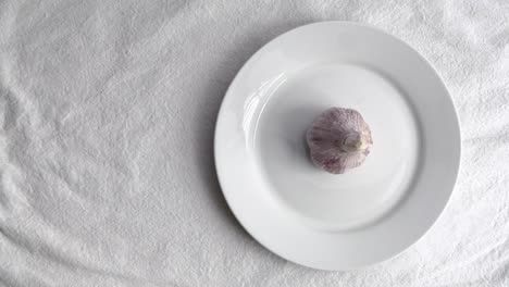 Garlic-on-white-ceramic-plate-on-white-table-mat