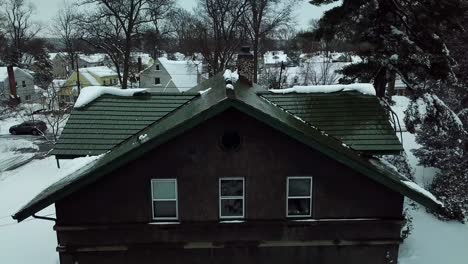 Snowy-push-in-of-Cabin-in-Suburban-neighborhood-Drone-shot