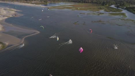 Drone-footage-of-many-kiteboarders-surfing-in-Combuco,-Brazil