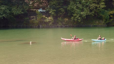 Slide-shot-of-people-kayaking-down-a-river-in-Kyoto,-Japan-4K-slow-motion