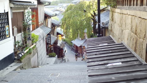 Beautiful-city-steps,-guy-walking-in-the-distance-in-Kyoto,-Japan-soft-lighting