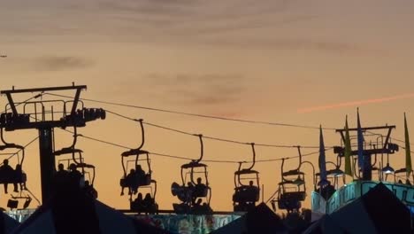 Setting-sun-silhouettes-the-sky-tram-ride-at-the-North-Carolina-State-Fair-in-Raleigh,-NC,-2019