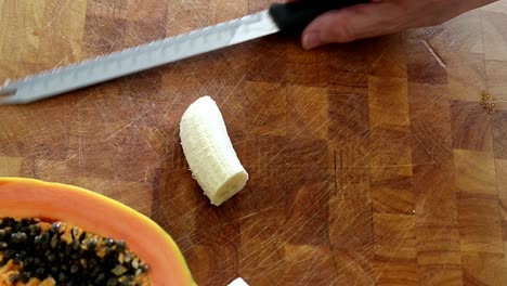 Cutting-a-peeled-banana-in-half