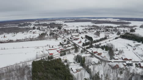 Red-barns-stand-out-on-white-winter-landscape-in-rural-location-with-blanket-of-new-white-snow-on-the-ground