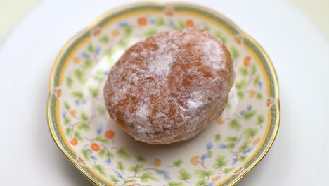 Der-Donut-Rollt-Auf-Dem-Teller.-Weißer-Hintergrund