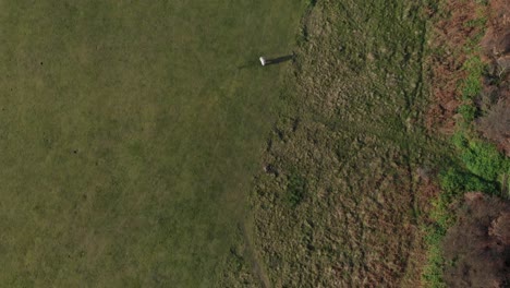 Aerial-overhead-clip-over-a-green-field-in-England,-Cromer-Cliffs