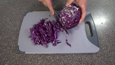 Cropped-view-of-a-man-slicing-red-cabbage-in-a-kitchen