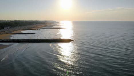 Scenic-aerial-drone-fly-over-shot-above-calm-sea-waves-and-jettys,-sunset,-calm-scene,-nobody,-seascape,-lifestyleaeri