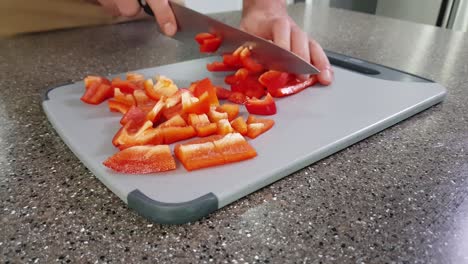 Closeup-of-hands-cutting-red-Bell-Peppers-on-a-chopping-board