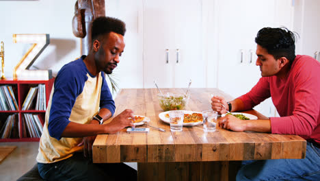 Gay-couple-interacting-with-each-other-while-having-meal