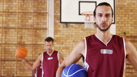Confident-basketball-player-holding-a-basketball