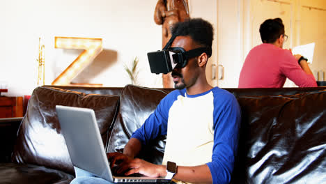 Hombre-Usando-Casco-De-Realidad-Virtual-Y-Computadora-Portátil-En-La-Sala-De-Estar