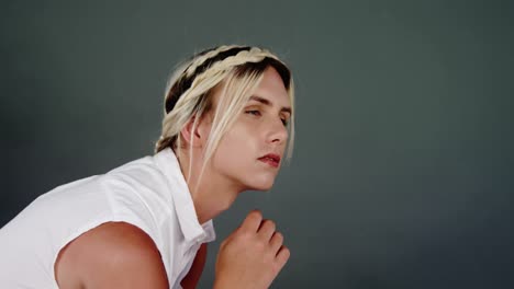 Androgynous-man-posing-against-green-background
