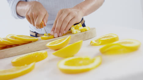 Mid-section-of-woman-cutting-fruits-on-chopping-board