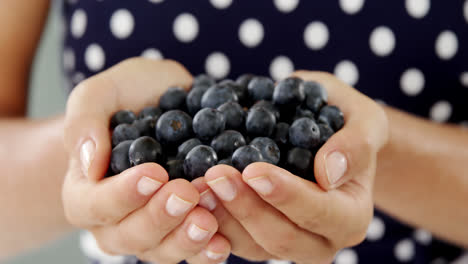 Close-up-of-woman-holding-blueberry