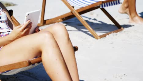 Schöne-Frau,-Die-Am-Strand-Musik-Auf-Einem-Digitalen-Tablet-Hört
