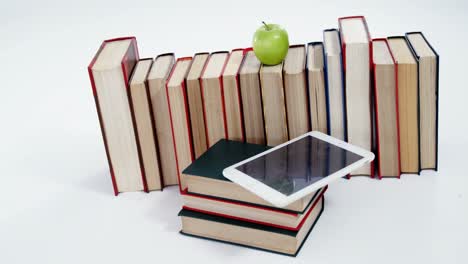 Apple,-digital-tablet-and-books-on-white-background