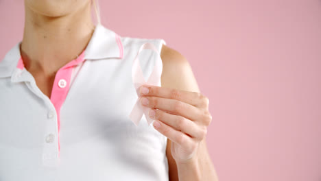 Mid-section-of-woman-holding-breast-cancer-awareness-ribbon