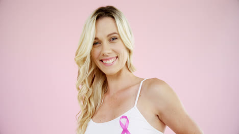 Smiling-woman-showing-breast-cancer-awareness-ribbon