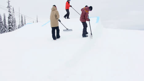 Gruppe-Von-Männern,-Die-Schnee-Im-Skigebiet-Reinigen
