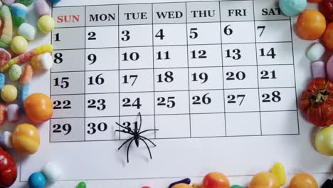 Fake-spider-on-a-calendar-with-various-sweet-foods-4k