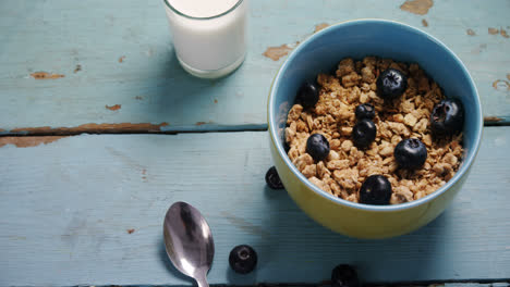 Muesli-and-blueberries-in-bowl-with-glass-of-milk-4k