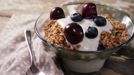 Bowl-of-yogurt-muesli,-cherries-and-blueberries-for-breakfast-4k