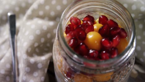 Yogurt-with-pomegranates-and-golden-berries-in-glass-jar-4k